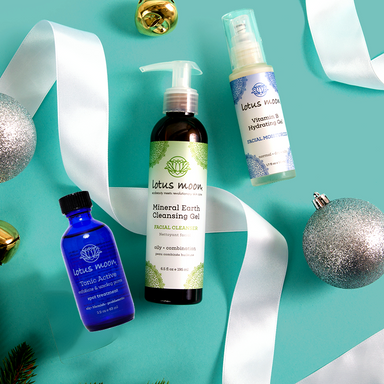Lotus Moon skincare products on a teal background with decorative ribbons and ornaments.